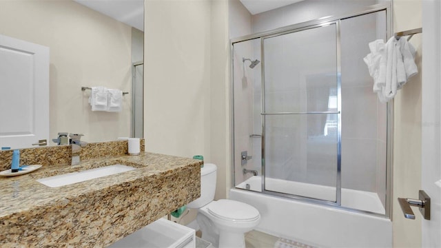 full bathroom featuring combined bath / shower with glass door, vanity, and toilet