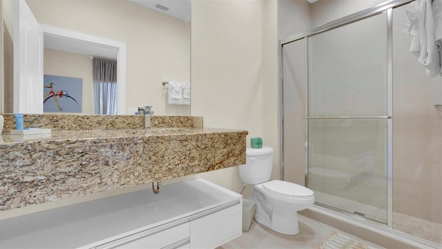 bathroom featuring tile patterned floors, toilet, and a shower with door