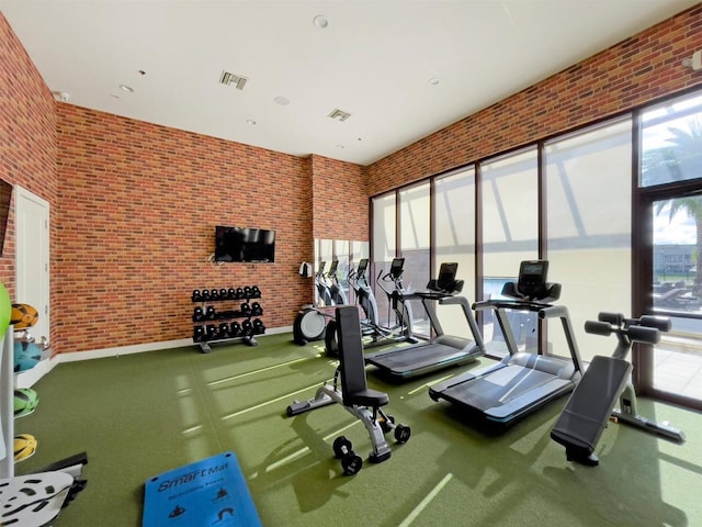 exercise room featuring brick wall