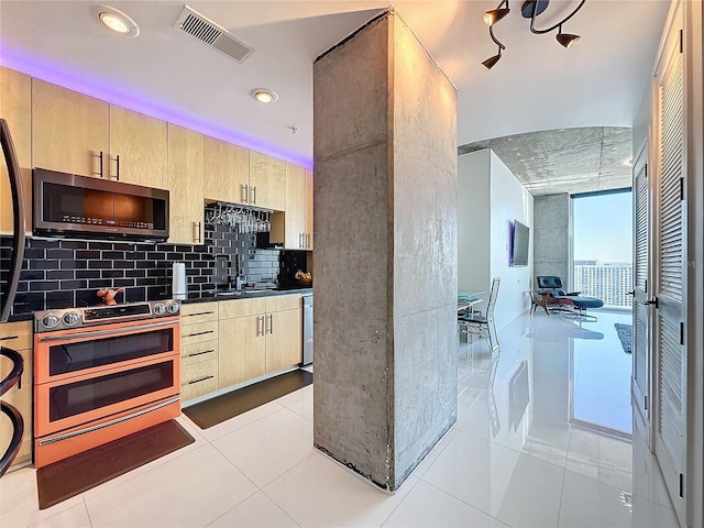 kitchen featuring decorative backsplash, light brown cabinets, stainless steel appliances, and light tile patterned flooring