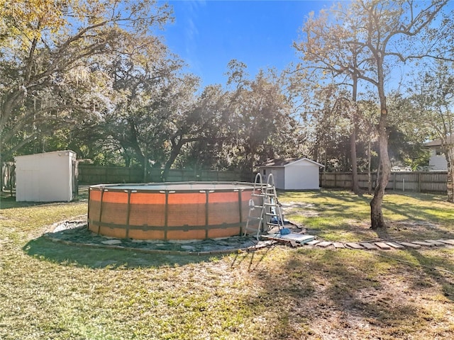 view of yard featuring a fenced in pool and a shed