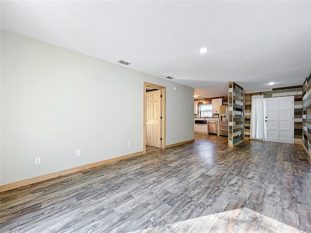 unfurnished living room featuring hardwood / wood-style floors and a textured ceiling