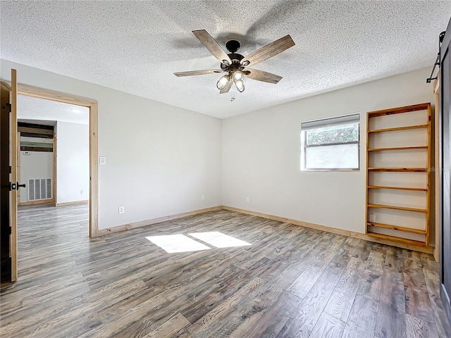 spare room with hardwood / wood-style flooring, ceiling fan, and a textured ceiling