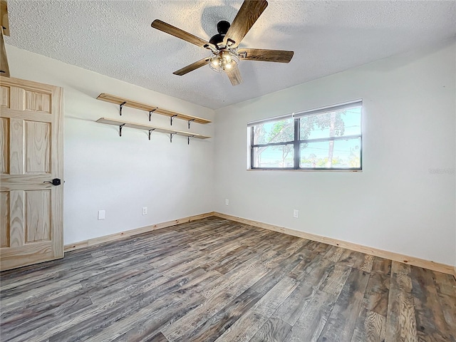 empty room featuring ceiling fan, dark hardwood / wood-style flooring, and a textured ceiling