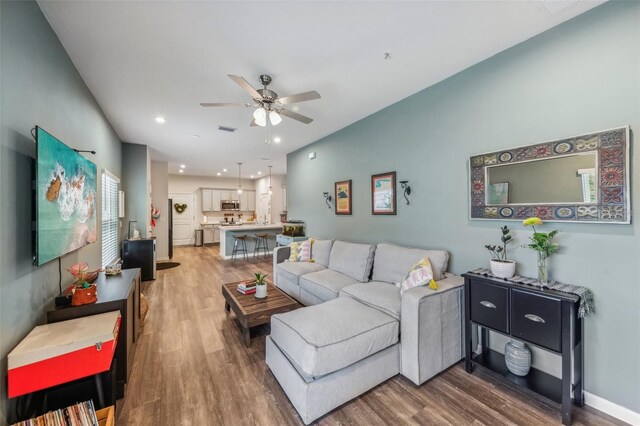 living room with hardwood / wood-style flooring and ceiling fan