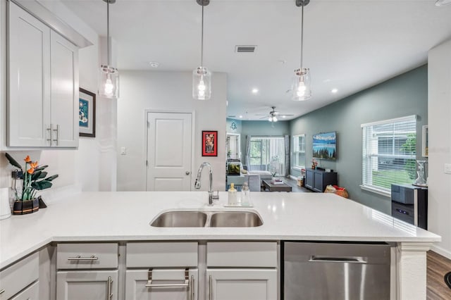 kitchen with kitchen peninsula, ceiling fan, decorative light fixtures, stainless steel dishwasher, and sink