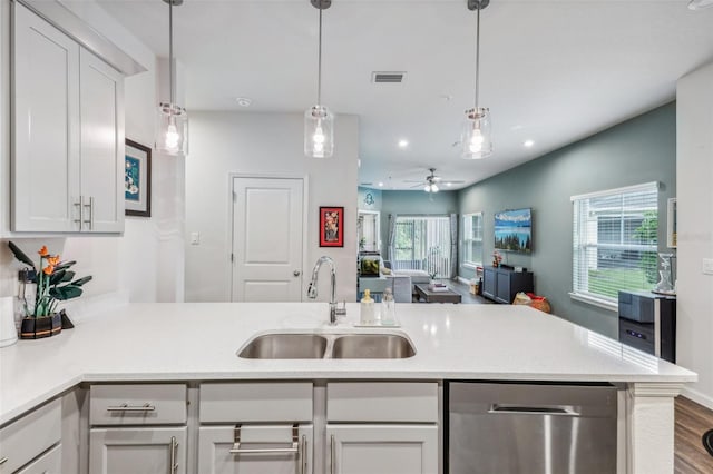 2920 Oak Park Way Apt A, Orlando, FL 32822 - kitchen with stainless steel dishwasher, a peninsula, light countertops, open floor plan, and white cabinetry