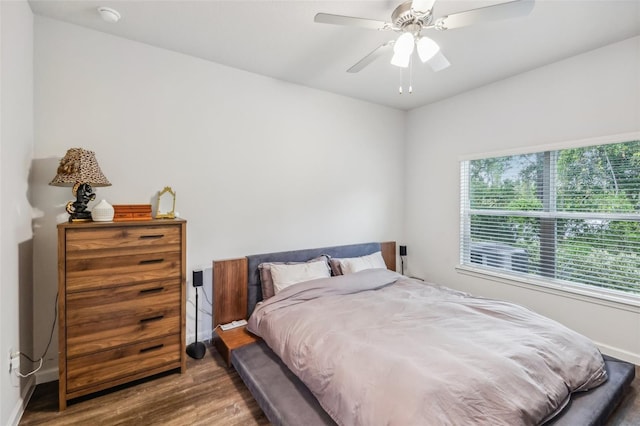 bedroom with ceiling fan, multiple windows, and hardwood / wood-style floors