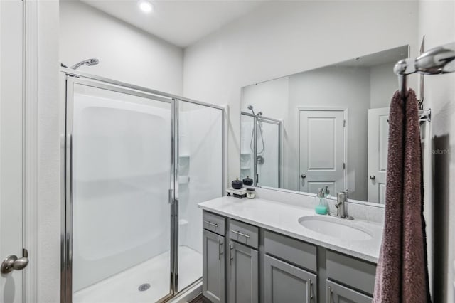 bathroom with a shower with shower door and vanity