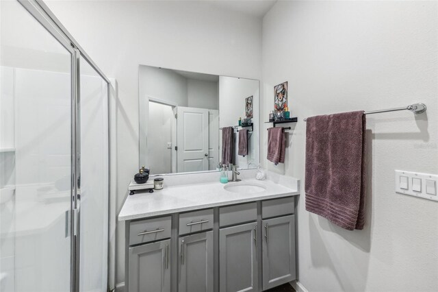 bathroom featuring vanity and a shower with door