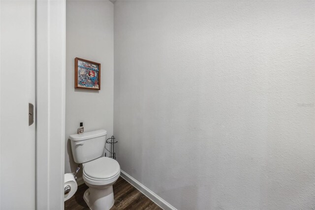 bathroom featuring wood-type flooring and toilet