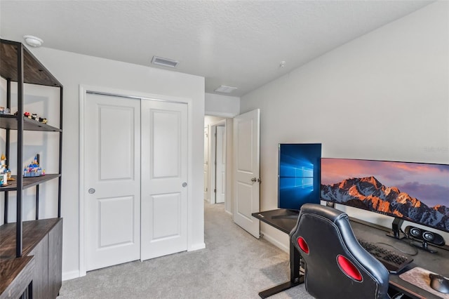 carpeted office space with a textured ceiling