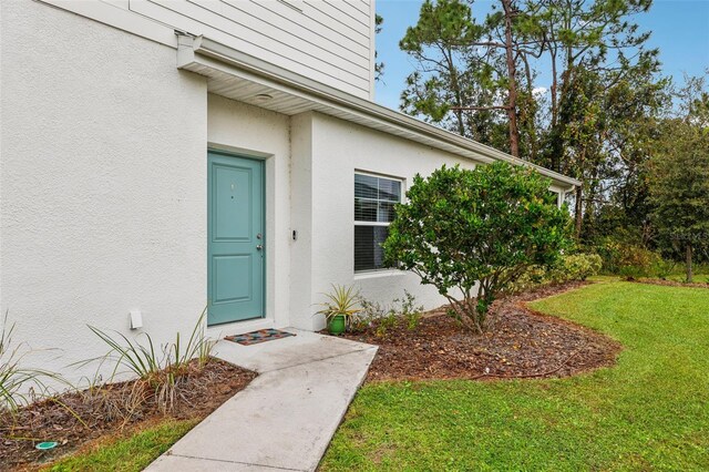 entrance to property with a lawn