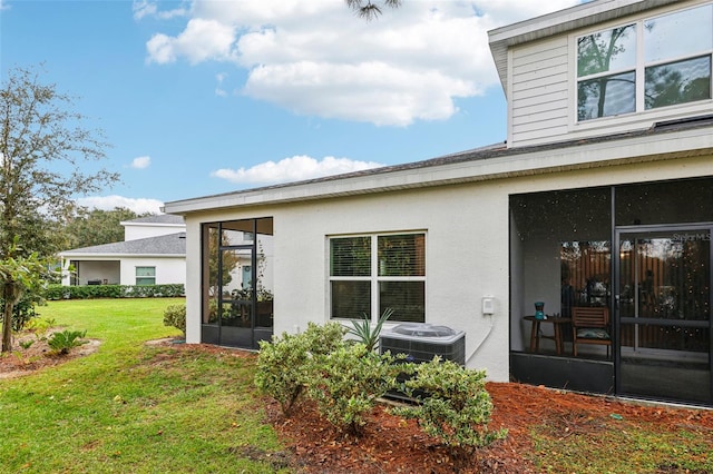 exterior space with a sunroom, a yard, and central AC unit