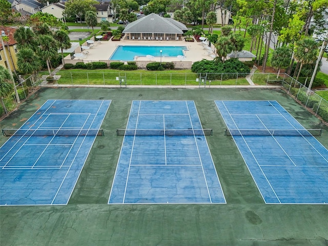 view of tennis court featuring a community pool and basketball hoop