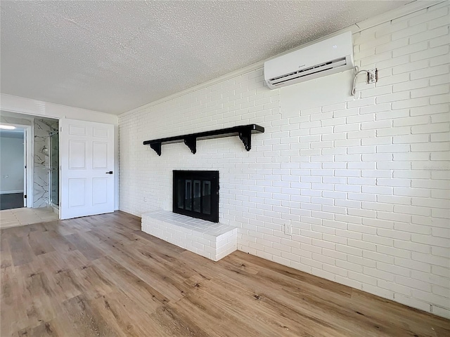 unfurnished living room with a wall mounted air conditioner, hardwood / wood-style flooring, and brick wall