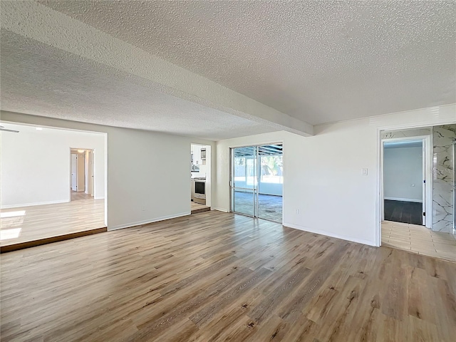 spare room featuring light hardwood / wood-style flooring and a textured ceiling