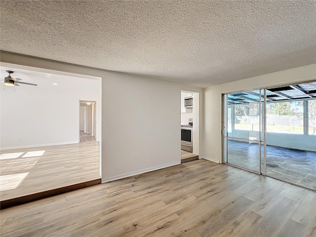 spare room with ceiling fan, light hardwood / wood-style floors, and a textured ceiling