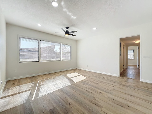 empty room with ceiling fan, light hardwood / wood-style floors, and a textured ceiling