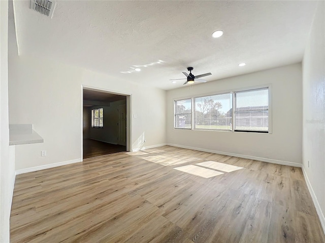 unfurnished room featuring a textured ceiling, light hardwood / wood-style floors, and ceiling fan