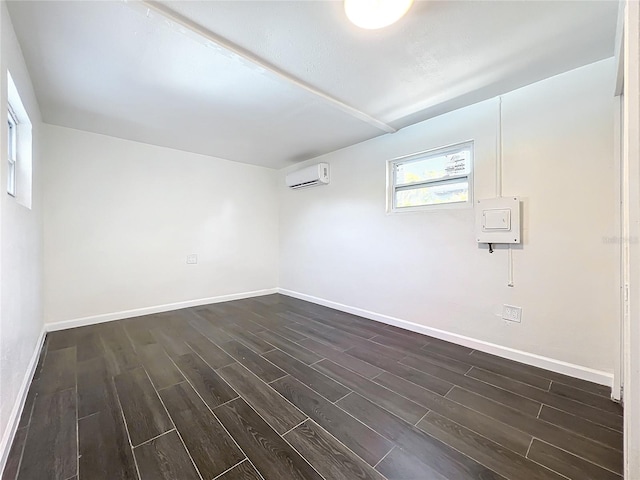 unfurnished room with a wall mounted AC and dark hardwood / wood-style floors