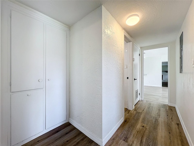 hallway with dark hardwood / wood-style flooring and a textured ceiling