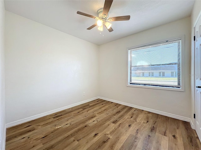 empty room with ceiling fan and light hardwood / wood-style flooring