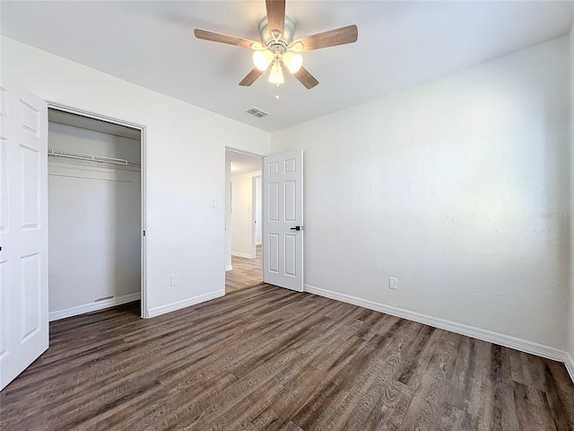 unfurnished bedroom with ceiling fan, dark hardwood / wood-style flooring, and a closet