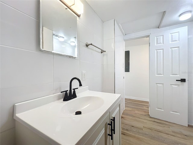 bathroom with vanity, wood-type flooring, and tile walls