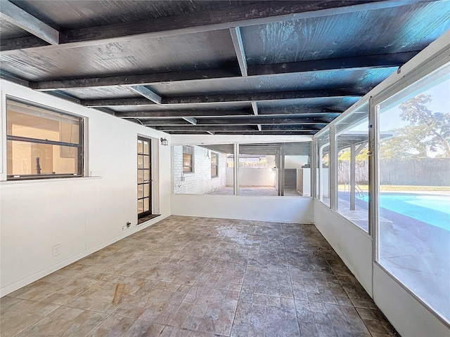 unfurnished sunroom with beamed ceiling