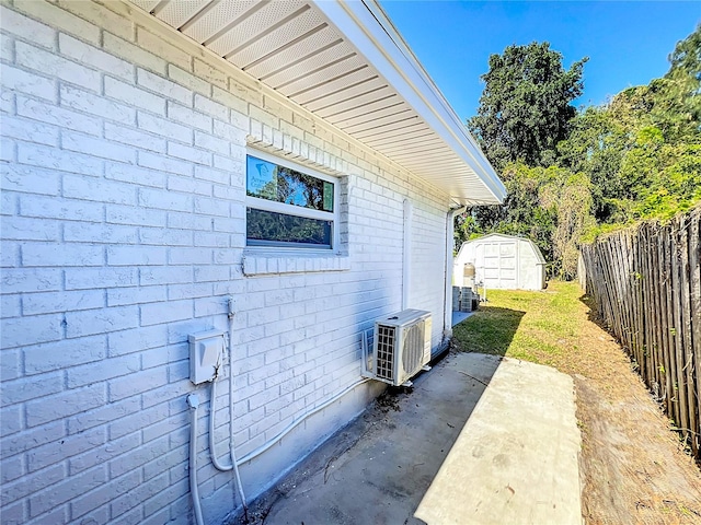 view of side of home with ac unit and a shed