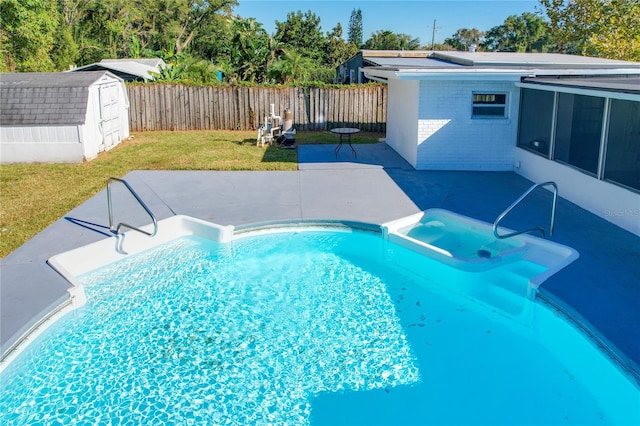 view of pool featuring a patio area, a yard, and a storage unit