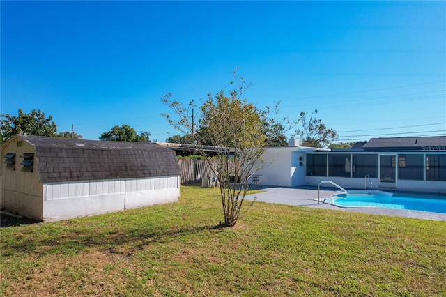 view of yard featuring a fenced in pool, a patio area, a sunroom, and a shed