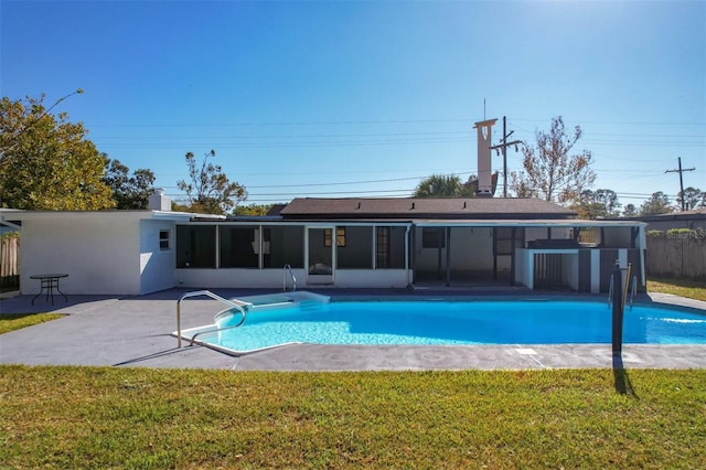 view of swimming pool featuring a sunroom, a patio area, and a yard