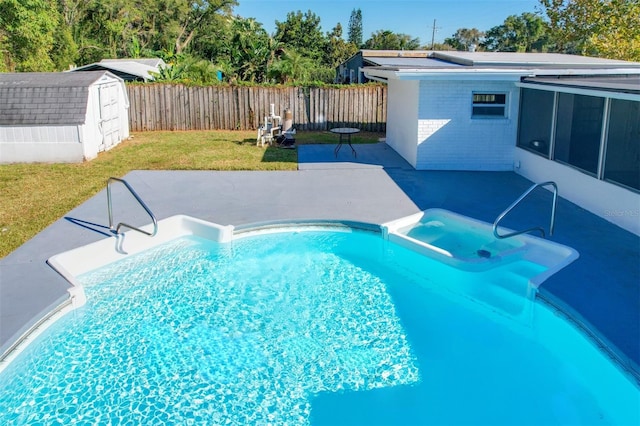 view of pool with a lawn, a patio area, and a storage shed