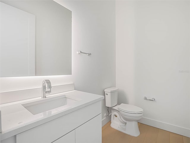 bathroom featuring vanity, wood-type flooring, and toilet