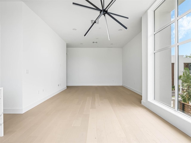 empty room with ceiling fan and light wood-type flooring