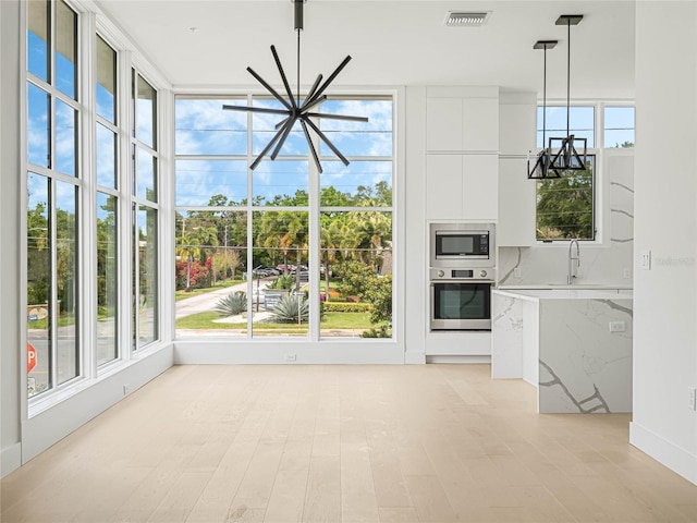 unfurnished living room with an inviting chandelier and sink