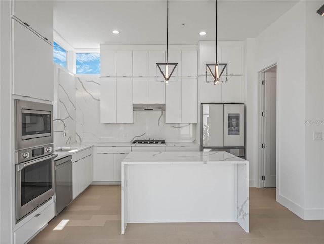 kitchen with stainless steel appliances, light hardwood / wood-style flooring, white cabinets, a center island, and hanging light fixtures