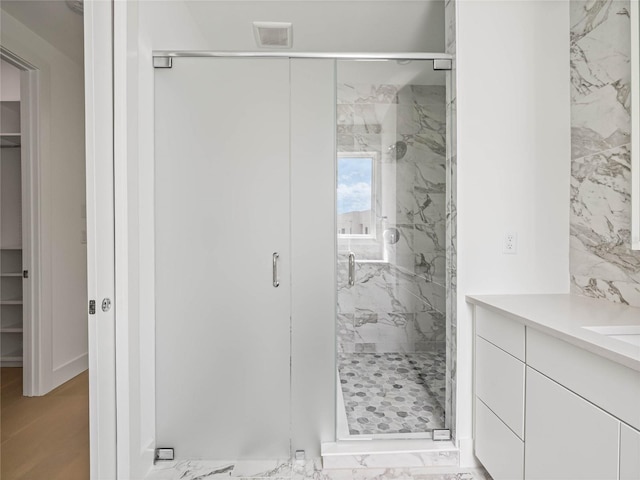 bathroom featuring vanity and a shower with shower door