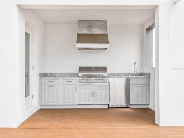 interior space with a grill, sink, and an outdoor kitchen