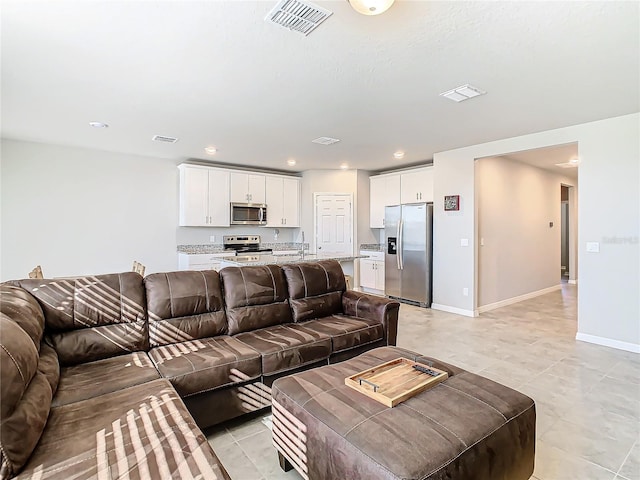 living room featuring sink and light tile patterned floors