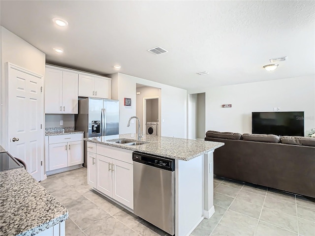 kitchen with a kitchen island with sink, white cabinets, sink, appliances with stainless steel finishes, and washer / clothes dryer