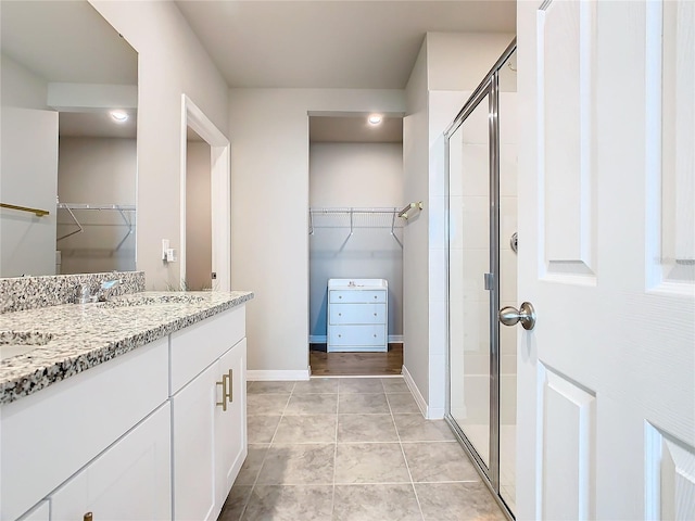 bathroom featuring tile patterned floors, vanity, and a shower with shower door