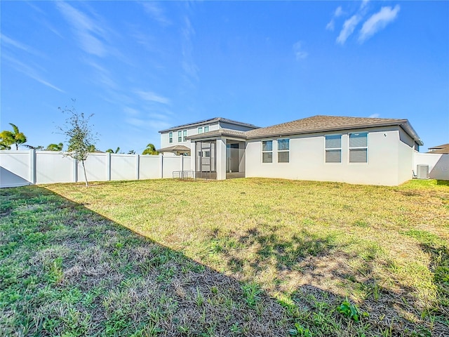 back of property with a sunroom and a lawn