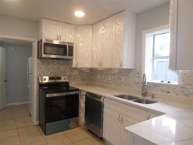 kitchen with stainless steel appliances, white cabinetry, a healthy amount of sunlight, and sink