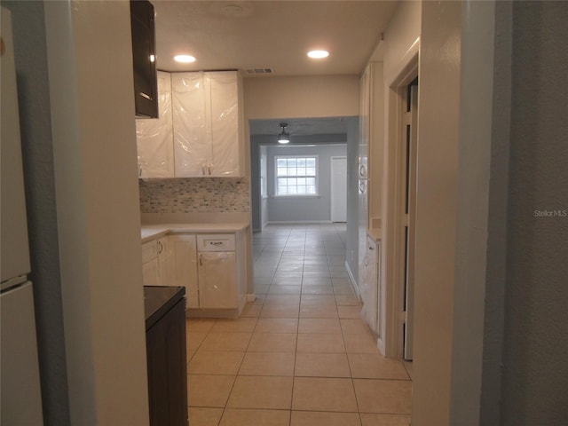 kitchen featuring light tile patterned floors, tasteful backsplash, and white cabinetry