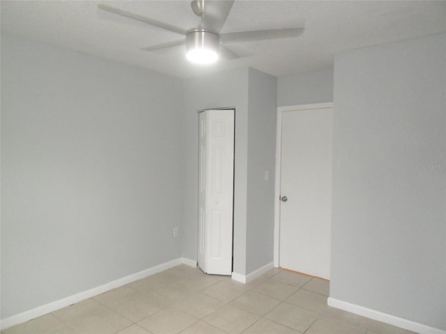 tiled spare room featuring ceiling fan