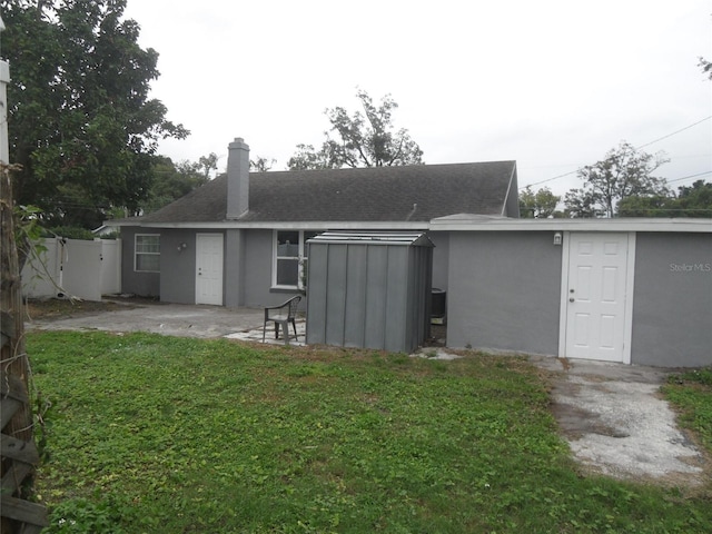 rear view of property featuring a lawn and a patio area