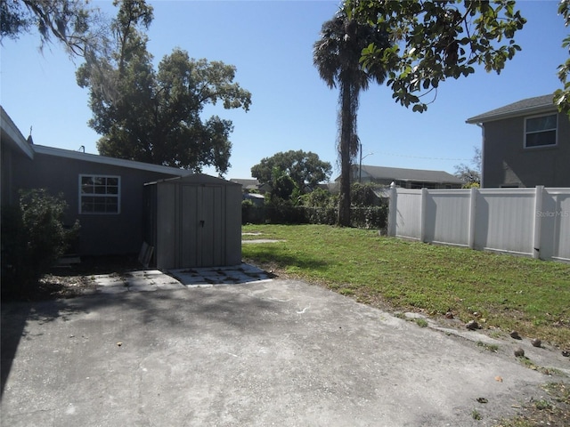 view of yard featuring a storage shed and a patio area